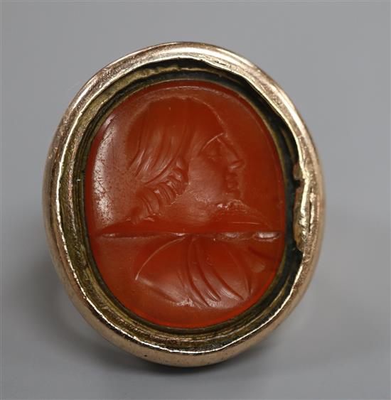 A large 19th century yellow metal and intaglio carnelian set signet ring, carved with the bust of a gentleman to sinister, size O.